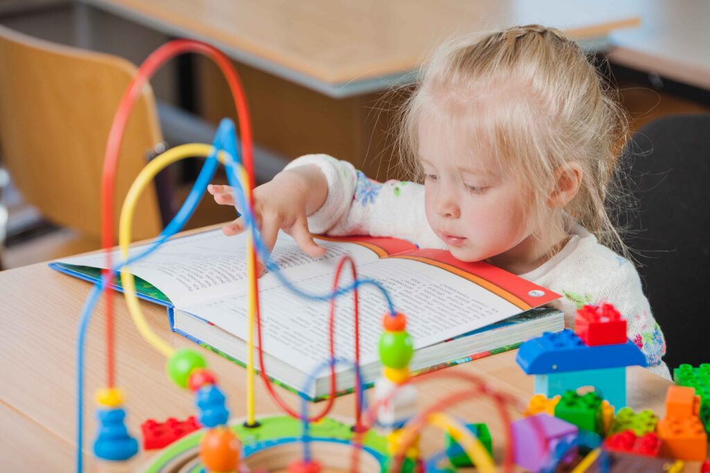 Fine Motor Skills- Cute little girl reading and learning